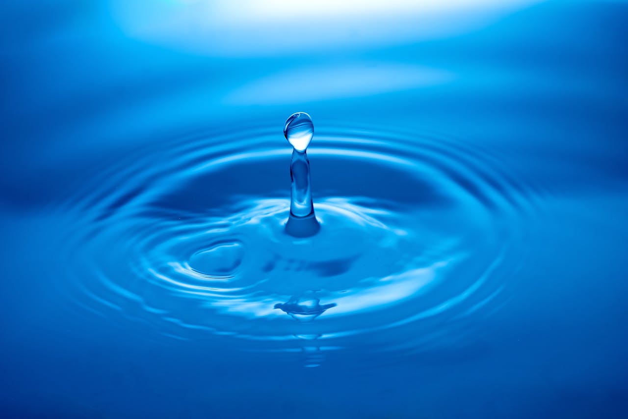 services-img Capture of a water droplet creating ripples on a blue surface showcasing tranquility and clarity.